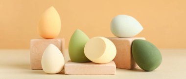 Bej arka planda makyaj süngeri olan dekoratif podyumlar