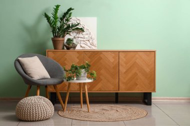 Oturma odasının içinde koltuk, masa ve çekmeceler var.