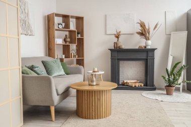 Dekoratif şöminesi ve kanepesi olan oturma odasının içinde.