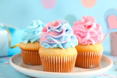 Mavi arka planda lezzetli kekler olan bir tabak. Cinsiyet ortaya çıkan parti kavramı