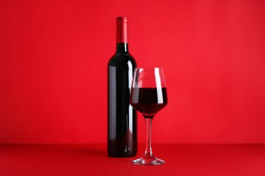 Renkli arka planda bir şişe kırmızı şarap.