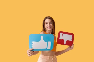 Turuncu arka planda ikonlar tutan ve sevmeyen güzel genç bir kadın.