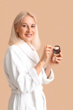 Bornozlu, krema kavanozlu, renkli bir kadın.