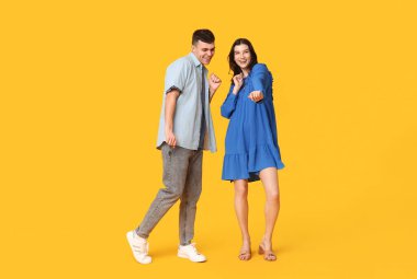 Güzel genç çift sarı arka plan üzerinde dans