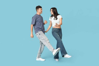 Mavi arka planda dans eden güzel genç çift