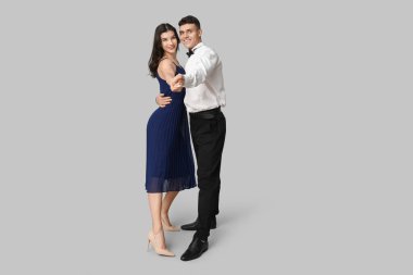 Gri arka planda dans eden mutlu genç çift