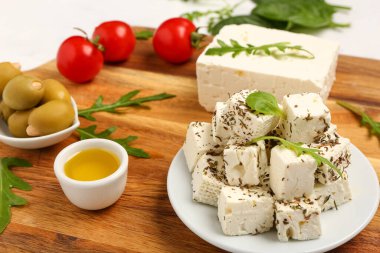 Tahta ahşap tabak ve nefis kesilmiş beyaz peynir.