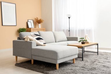 Gri kanepesi, sehpası ve resmi olan şık bir oturma odası.