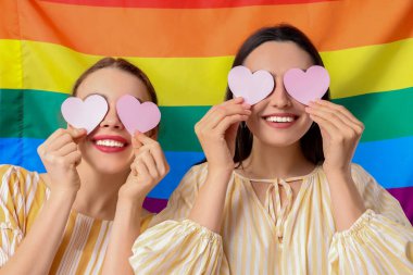 LGBT arka planında kağıt kalpli güzel lezbiyen çift