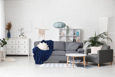 Yumuşak kanepesi, koltuğu ve sehpası olan şık bir oturma odası.