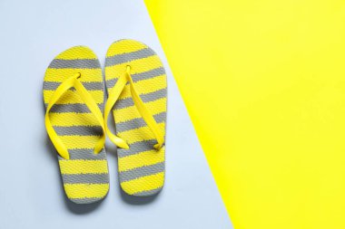 Renkli arkaplanda şık çizgili parmak arası terlikler