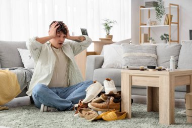 Kirli ayakkabılarıyla şoka uğramış genç bir adam.