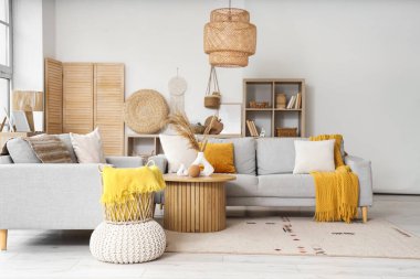 Oturma odasının içi rahat gri koltuklar ve kahve masasıyla dolu.