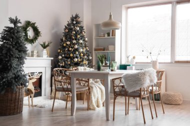 Masası, şöminesi ve Noel ağaçları olan hafif yemek odasının içi.