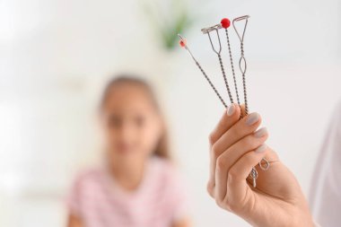 Ofisteki küçük kıza karşı logopedik araştırma yapan kadın konuşma terapisti.