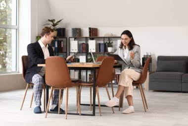 Ofisteki masada çalışan genç iş adamları. Ulusal İş Günü Pijamalarınızı Giyin
