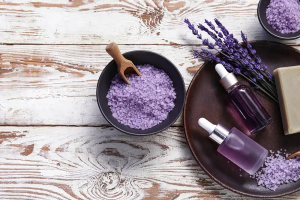 Ahşap zemin üzerinde deniz tuzu ve şişe lavanta yağıyla güzel bir kompozisyon, yakın plan.