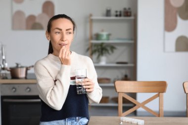 Mutfakta ilaç alan kadın.