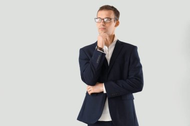 Hafif arka planda gözlüklü düşünceli bir iş adamı.