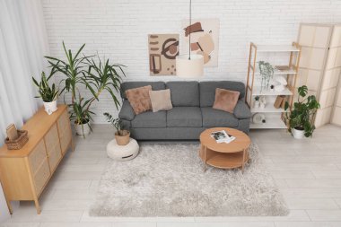 Rahat gri bir kanepe ve şık bir odanın içindeki kahve masası.