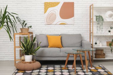 Rahat kanepesi, sehpası ve çiçekleri olan bir oturma odası.