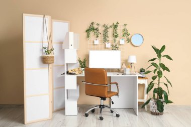 Çalışma alanı, katlama ekranı ve bilgisayarı olan ofis içi