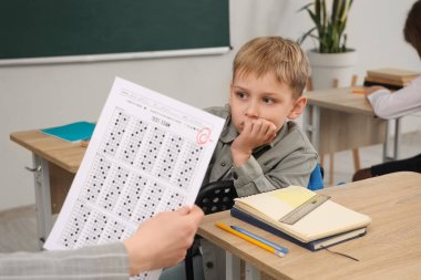 Sınıftaki öğretmenden C notu alan endişeli öğrenci.