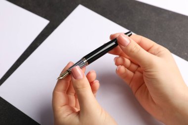 Siyah masaya boş bir defterle kadın el yazısı, yakın plan.