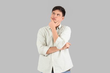 Aydınlık arka planda merak eden genç adam