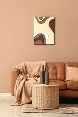 Sıcak kanepe ve kahve masası. Odada kahverengi duvarın yanında şişeler var.