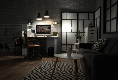 Geceleri çalışma yeri, kanepesi ve parlayan lambaları olan karanlık programcı ofisinin içinde.