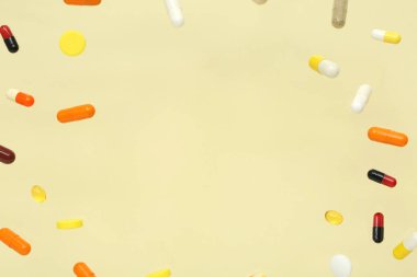 Sarı arka planda uçan renkli haplardan yapılmış çerçeve