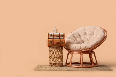 Şık koltuk, sehpa ve bej arka planda klasik bavul.