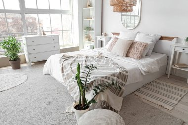 Rahat yatağı, çekmeceleri ve aynası olan şık bir yatak odası.