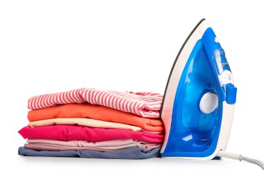 Beyaz arka planda izole edilmiş temiz giysi yığınına sahip modern demir.