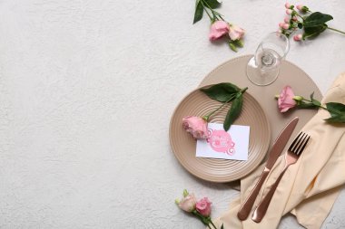 Tebrik kartı ve beyaz arka planda Eustoma çiçekleri olan güzel bir masa. Anneler Günü kutlaması