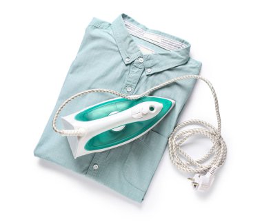 Beyaz arka planda katlanmış temiz gömlekli modern elektrikli ütü.