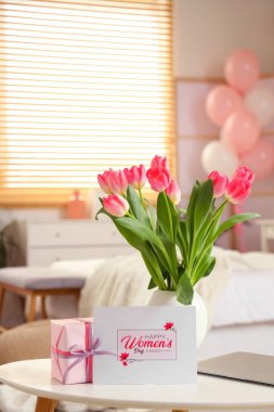 Yatak odasındaki kadınlar günü için laleli vazo, hediye ve tebrik kartı.