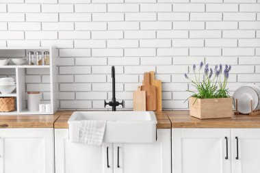 Güzel Muscari çiçekleri ve mutfak aletleri mutfaktaki lavabonun yanındaki ahşap tezgahta.