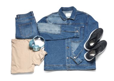 Beyaz arka planda şık erkek kıyafetleri, ayakkabıları ve modern kulaklıkları var.