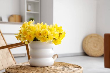 Oturma odasında üzerinde nergis olan vazo, yakın plan.