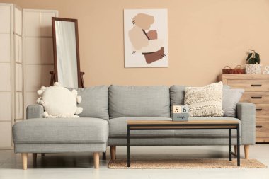 Oturma odasının içinde kanepe, masa ve ayna var.