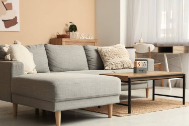 Masada kanepe, işyeri ve geri sayım takvimi olan oturma odası.