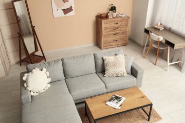 Oturma odasının içinde kanepe, işyeri ve ayna var.