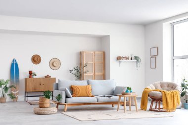 Sörf tahtası, kanepesi ve koltuğu olan bir oturma odası.