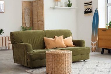 Sörf tahtası ve yeşil kanepeli bir oturma odası.