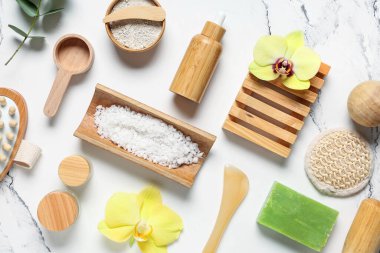 Farklı kozmetik ürünleri, spa aksesuarları ve açık arkaplanda orkide çiçekleri içeren kompozisyon