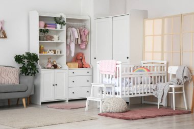 Bebek beşiği, dolap ve katlama ekranlı bebek odasının içi.