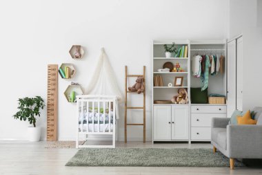 Bebek beşiği, dolap ve merdiveni olan bebek odasının içinde.