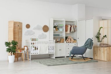 Bebek beşiği, dolabı ve sallanan koltuğu olan ışık kreşinin içinde.